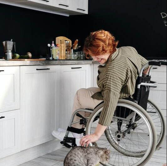 Women in wheelchair petting her cat