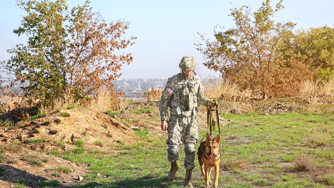 Male soldier with dog outside